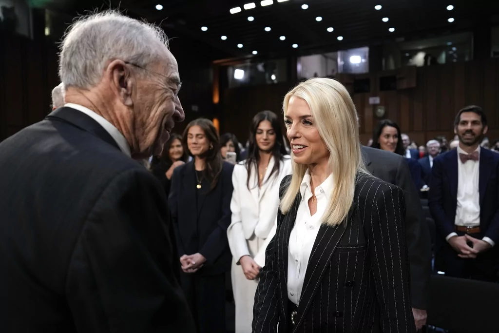 Pam Bondi, President-elect Donald Trump's choice to lead the Justice Department as attorney general, speaks with Chairman Chuck Grassley, R-Iowa, before the Senate Judiciary Committee for her confirmation hearing, at the Capitol in Washington, Wednesday, Jan. 15, 2025. (AP Photo/Ben Curtis)