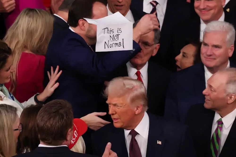 Democrat holds sign "this is not normal" at President Donald Trump's address to Congress on March 4, 2025. (Graeme Jennings/Washington Examiner)