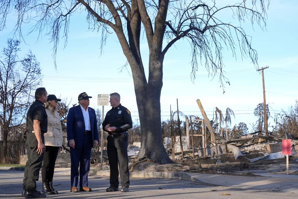 President Donald Trump and first lady Melania Trump walk with Jason Hing, chief deputy of emergency services at the Los Angles Fire Department, left, and Capt. Jeff Brown, chief of Station 69, as they tour the Pacific Palisades neighborhood affected by recent wildfires in Los Angeles, Friday, Jan. 24, 2025. (AP Photo/Mark Schiefelbein)