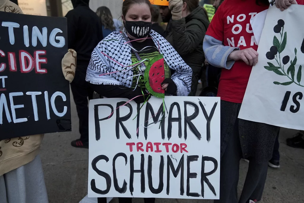 Demonstrators gather in front of the Central Library branch of the Enoch Pratt Free Library in Baltimore after Senate Democratic Leader Chuck Schumer's scheduled book tour event was postponed, Monday, March 17, 2025. (AP Photo/Stephanie Scarbrough)