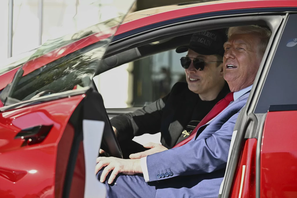 President Donald Trump and Tesla CEO Elon Musk speak to reporters as they sit in a red Model S Tesla vehicle on the South Lawn of the White House Tuesday, March 11, 2025, in Washington. 