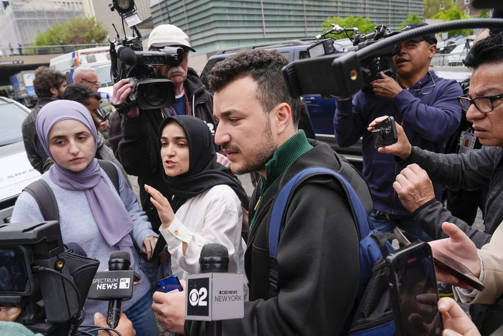 Members of the Columbia University Apartheid Divest group, including Sueda Polat, second from left, and Mahmoud Khalil, center, are surrounded by members of the media outside the Columbia University campus, Tuesday, April 30, 2024, in New York.