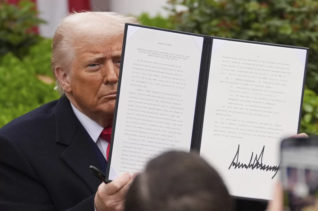 President Donald Trump holds a signed executive order during an event to announce new tariffs in the Rose Garden of the White House, Wednesday, April 2, 2025, in Washington