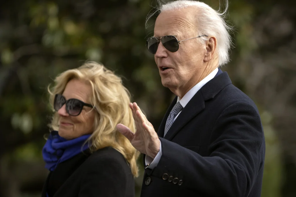 President Joe Biden gestures as he and first lady Jill Biden walk across the South Lawn of the White House, Thursday, Jan. 2, 2025, in Washington, after returning from Camp David. (AP Photo/Mark Schiefelbein)