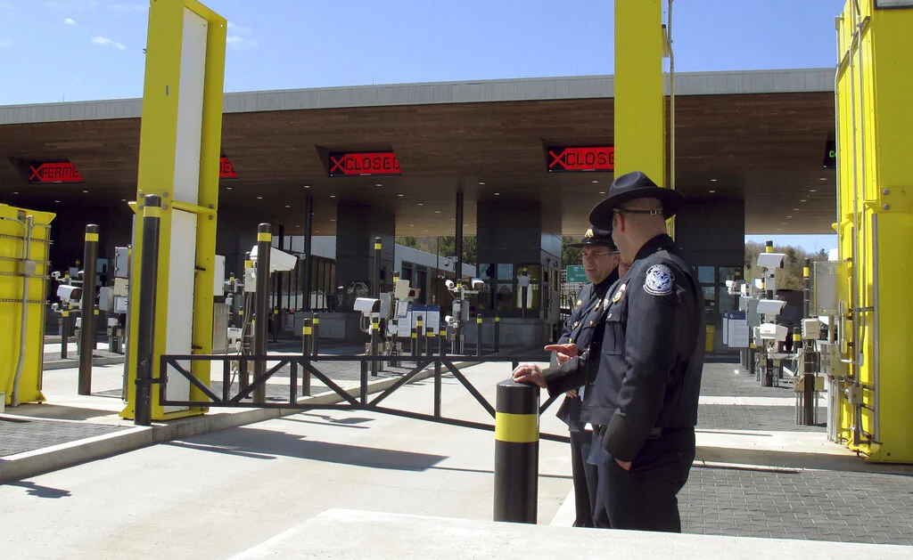 In this May 8, 2019 photo, U.S. Customs and Border Protection officials stand at the new border crossing facility on the U.S.-Canadian border in Derby Line, Vt. Court documents say federal agents seized almost 370 pounds (166.6 kilos) of cocaine that was hidden in a truck that was preparing to enter Canada at the Derby Line border crossing on Dec. 7. (AP Photo/Wilson Ring, File)