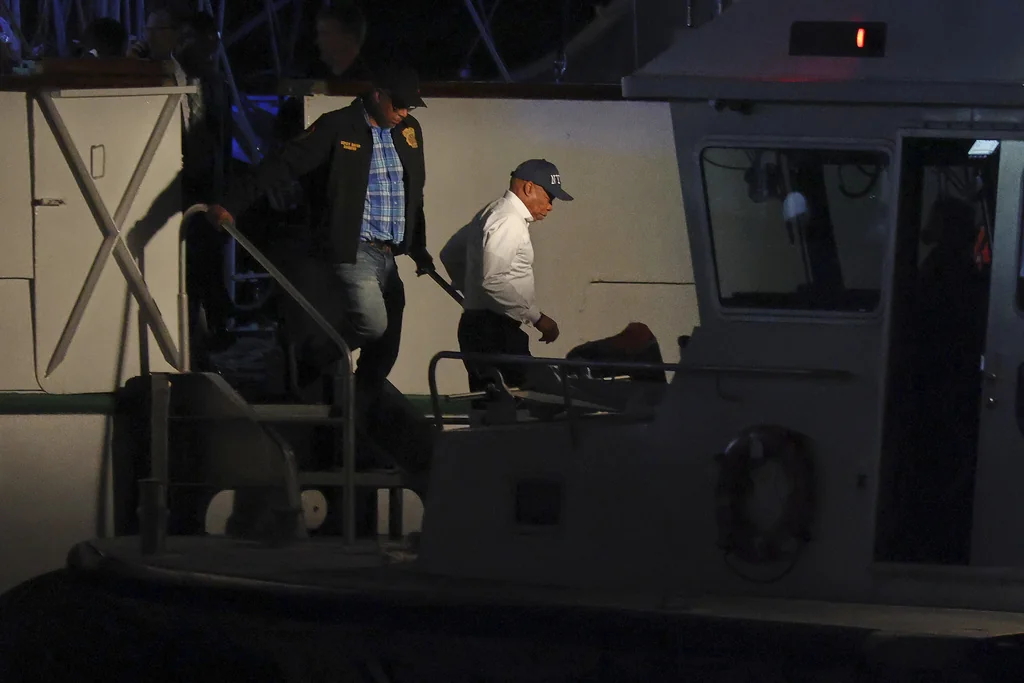 New York Mayor Eric Adams, right, disembarks a masted Mexican Navy training ship after boarding it with a New York Police Harbor Unit after it collided with the Brooklyn Bridge, Saturday, May 17, 2025, in New York.