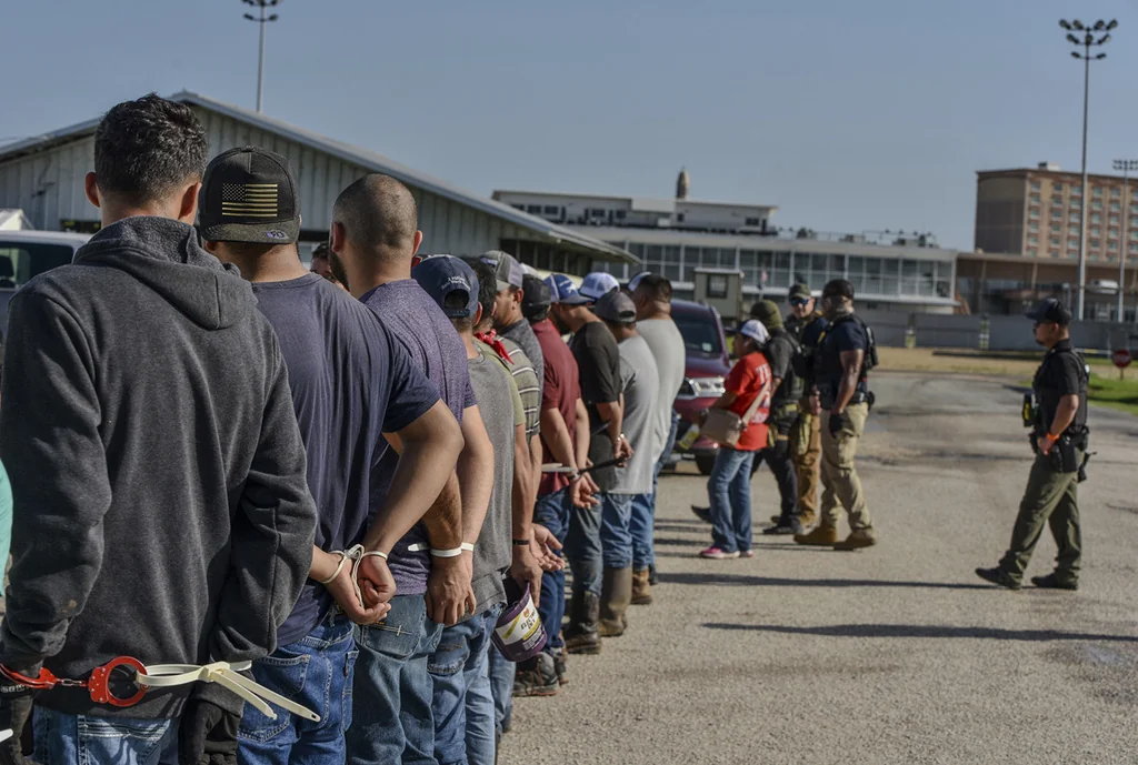 Workers stand handcuffed after being arrested by U.S. Immigration and Customs Enforcement, ICE, at Delta Downs Racetrack, Hotel and Casino in Calcasieu Parish, near Vinton, La., on Wednesday, June 18, 2025. (U.S. Immigration and Customs Enforcement via AP)
