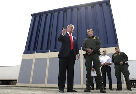 FILE - In this March 13, 2018, file photo, President Donald Trump speaks during as he reviews border wall prototypes, in San Diego, as Rodney Scott, the Border Patrol's San Diego sector chief, listens. Congress is heading toward a post-election showdown over President Donald Trump’s border wall, as GOP leaders signal they’re willing to engage in hardball tactics that could spark a partial government shutdown and the president revs up midterm crowds for the wall, a centerpiece of his 2016 campaign and a top White House priority. (AP Photo/Evan Vucci, File)