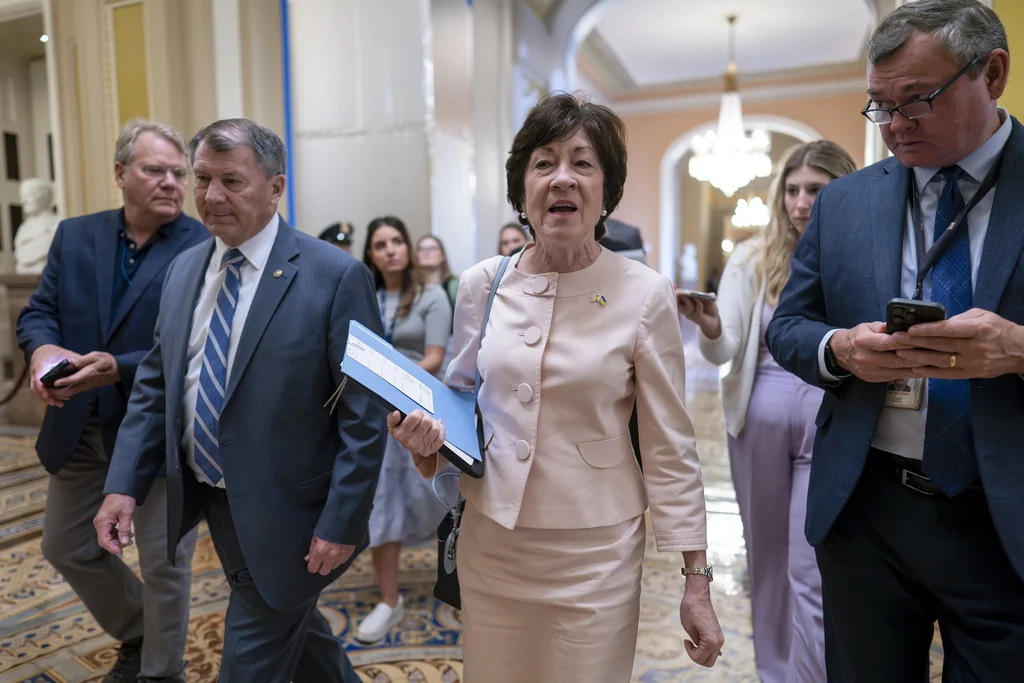 Sen. Susan Collins, R-Maine, center, joined at left by Sen. Mike Rounds, R-S.D., arrives at the Senate chamber at the Capitol in Washington, Thursday, June 1, 2023.
