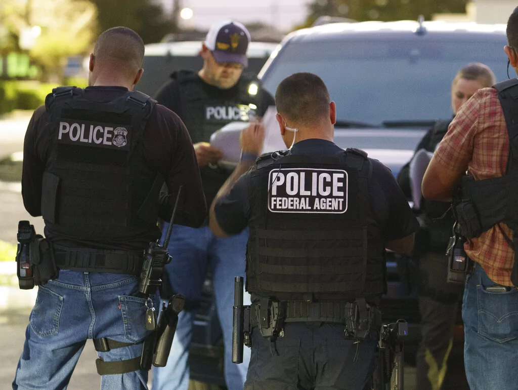 Immigration and Customs Enforcement agents gather before a raid to arrest immigrants considered a threat to public safety and national security during an early morning raid in Compton, California, Monday, June 6, 2022.