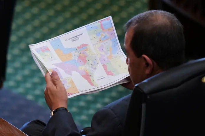 Texas state Sen. Pete Flores, R-Pleasanton, looks over a redrawn U.S. congressional map during debate over a bill in the Senate Chamber at the Texas Capitol in Austin, Texas, Friday, Aug. 22, 2025.