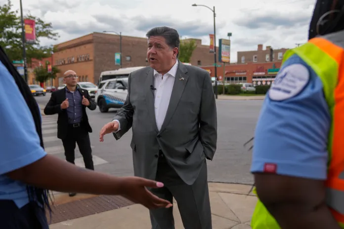Gov. JB Pritzker (D-IL) talks with two crossing guards Wednesday, Aug. 27, 2025, in the Bronzeville neighborhood of Chicago.