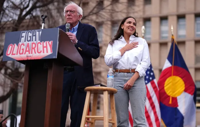 Sen. Bernie Sanders, I-Vt., left, speaks as Rep. Alexandria Ocasio-Cortez, D-N.Y., responds to calls of support during a stop of their "Fighting Oligarchy" tour that filled Civic Center Park, Friday, March 21, 2025, in Denver.