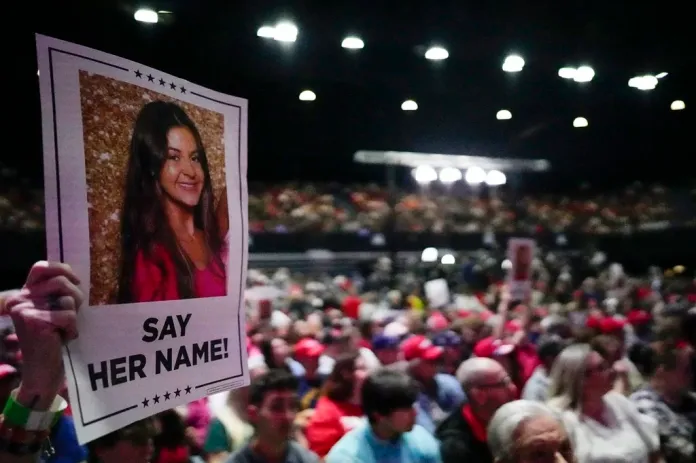 A supporter holds a sign with a photo of Laken Riley before Republican presidential candidate former President Donald Trump speaks at a campaign rally Saturday, March 9, 2024, in Rome Ga. (AP Photo/Mike Stewart)