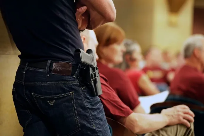 A Glock handgun is holstered on the side of Kristopher Kranz of Bloomington, Minnesota, as he listens during public testimony on Aug. 20, 2013, in St. Paul, Minnesota.