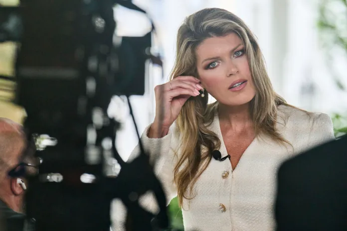 Lindsey Halligan fixes an earring at the end of an interview outside of the White House.