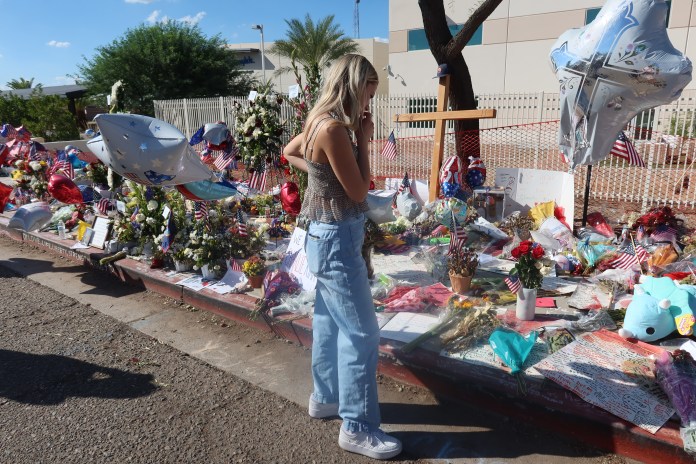 Paige Lowell, a 19-year-old conservative from Gilbert, Arizona, pays her respects to Charlie Kirk at a makeshift memorial at Turning Point USA's offices in Phoenix (Samantha-Jo Roth, Washington Examiner)