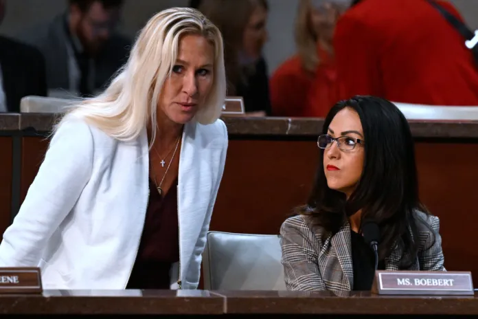 Rep. Marjorie Taylor Greene (R-GA), left, takes her seat next to Rep. Lauren Boebert (R-CO).