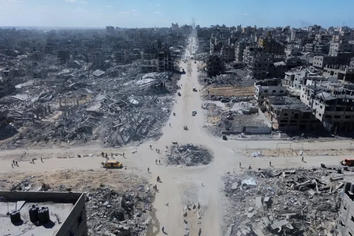 Palestinians walk among the rubble of Gaza City