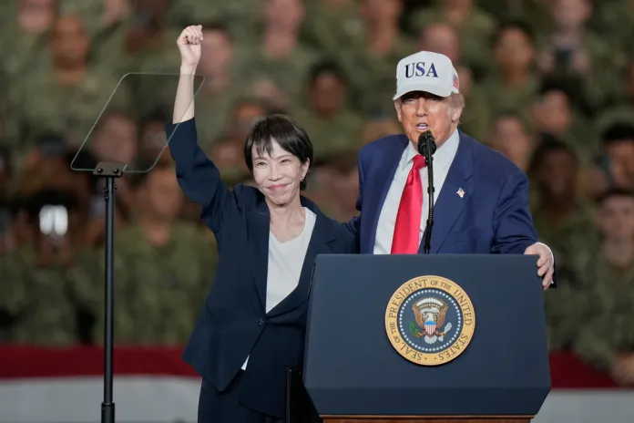 Japanese Prime Minister Sanae Takaichi, left, gestures as U.S. President Donald Trump delivers his speech during their visit to the aircraft carrier USS George Washington at the U.S. Navy's Yokosuka base, in Yokosuka, south of Tokyo, Tuesday, Oct. 28, 2025.