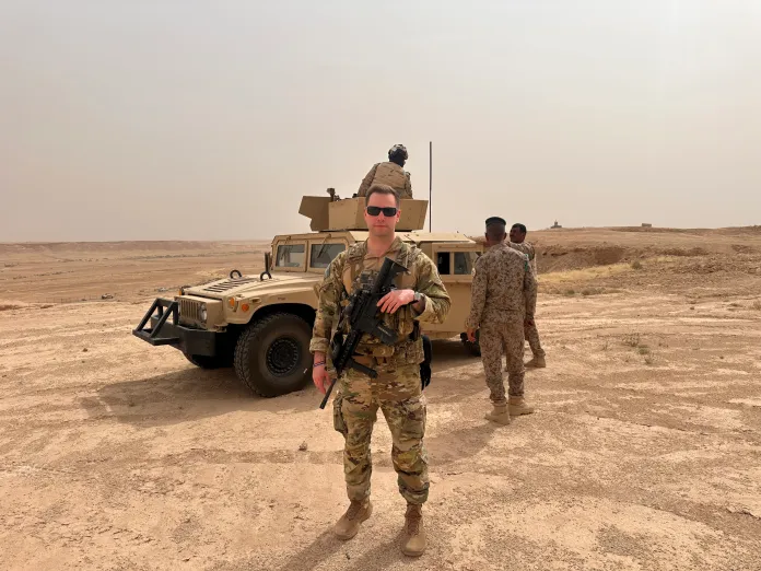 Michael Bouchard stands in front of a Humvee.
