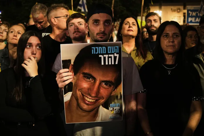 Freed Israeli hostage Matan Angrest holds a photo of Hadar Goldin, an Israeli soldier killed in 2014 whose body has been held in Gaza since then, during a rally calling for the return of the deceased hostages who are held by Hamas in the Gaza Strip, in Tel Aviv, Israel, Saturday, Nov. 8, 2025.