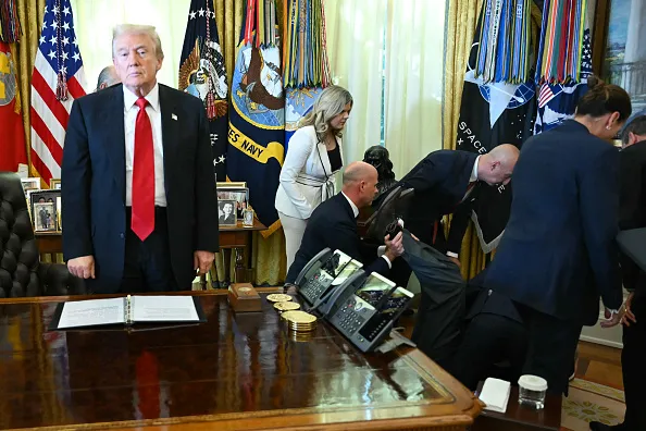 US President Donald Trump looks on after a man fainted during an announcement about weight-loss drugs in the Oval Office of the White House in Washington, DC on November 6, 2025. Trump announced deals Thursday with pharmaceutical giants Eli Lilly and Novo Nordisk to lower the prices of some popular weight-loss drugs. Both companies "have agreed to offer their most popular GLP-1 weight-loss drug," Trump said, "at drastic discounts."