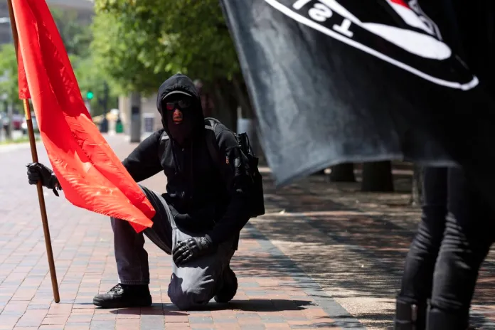 Anti-fascist protesters hold flags on the Christian Science Plaza in Boston.