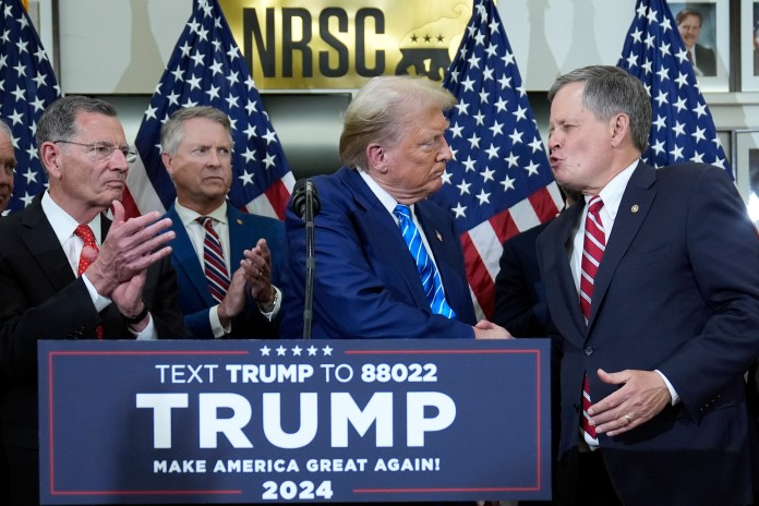 Republican presidential candidate former President Donald Trump shakes hands with Sen. Steve Daines, R-Mont., at the National Republican Senatorial Committee, Thursday, June 13, 2024, in Washington. (AP Photo/Evan Vucci)