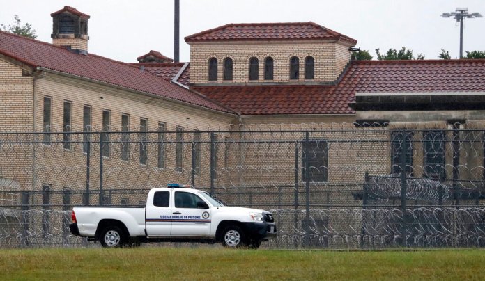 A Federal Bureau of Federal Prisons truck drives past barbed wire fences at the Federal Medical Center prison in Fort Worth, Texas, Saturday, May 16, 2020. Hundreds of inmates inside the facility have tested positive for COVID-19 and several inmates have died with numbers expected to rise. (AP Photo/LM Otero)