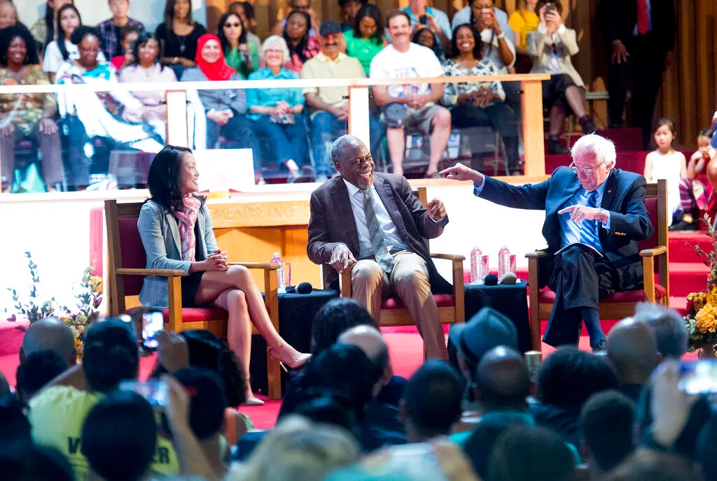 Democratic presidential candidate Sen. Bernie Sanders jokes with actor Danny Glover during a campaign rally.