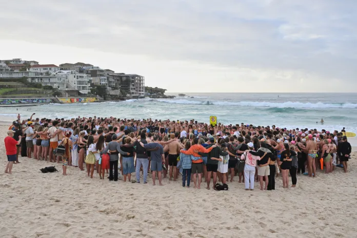 Swimmers gather for a morning vigil in Sydney following a shooting.