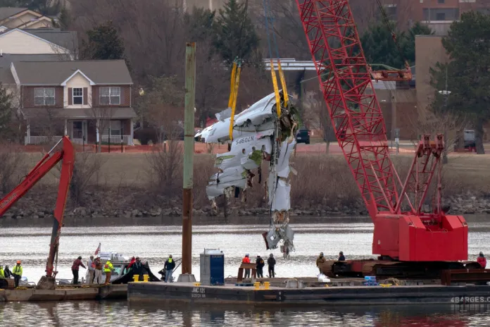 Rescue and salvage crews with cranes pull up the wreckage of an American Airlines jet in the Potomac River from Ronald Reagan Washington National Airport, Monday, Feb. 3, 2025, in Arlington, Va. (AP Photo/Jose Luis Magana)