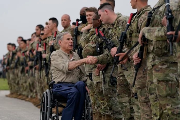 Texas Gov. Greg Abbott, left, shakes hands with members of the Texas National Guard as they prepare to deploy to the Texas-Mexico border in Austin, Texas, Monday, May 8, 2023. The Title 42 policy, a federal rule that has allowed the government to strictly regulate border entries, is set to expire this week. (AP Photo/Eric Gay)