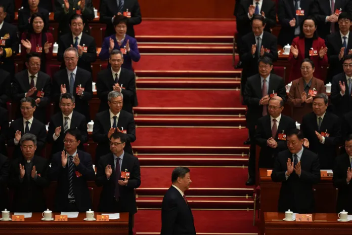 Xi Jinping walks before members of the Chinese Communist Party at a congressional meeting in Beijing