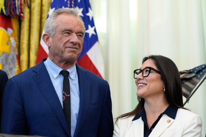 Health and Human Services Secretary Robert F. Kennedy Jr. and Labor Secretary Lori Chavez-DeRemer listen as President Donald Trump speaks in the Oval Office of the White House.
