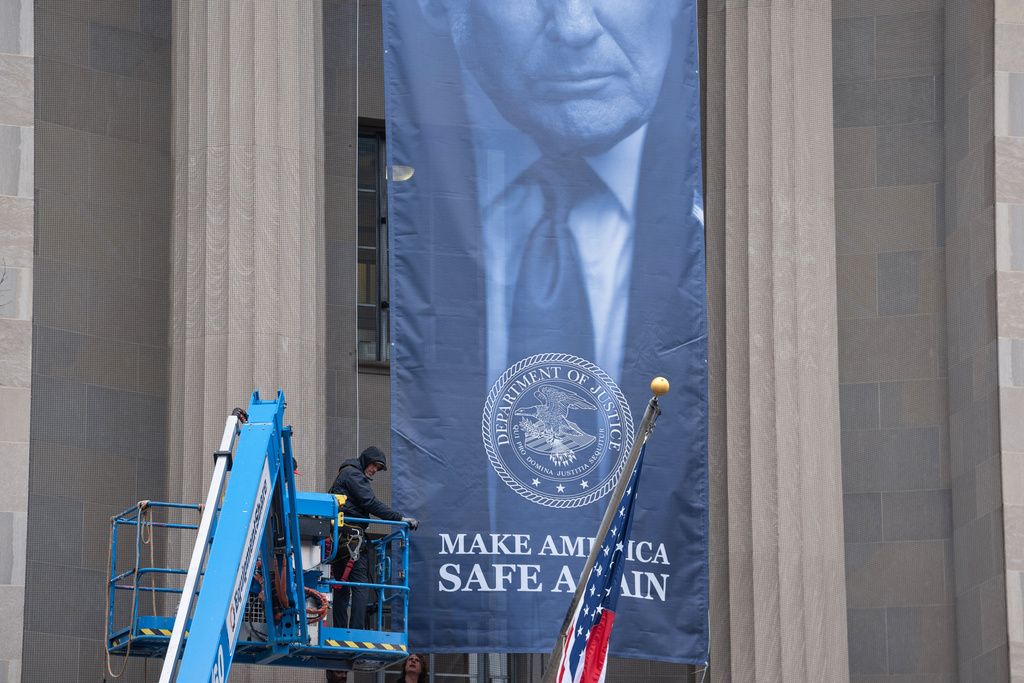 A banner showing President Donald Trump is hung from the Department of Justice.