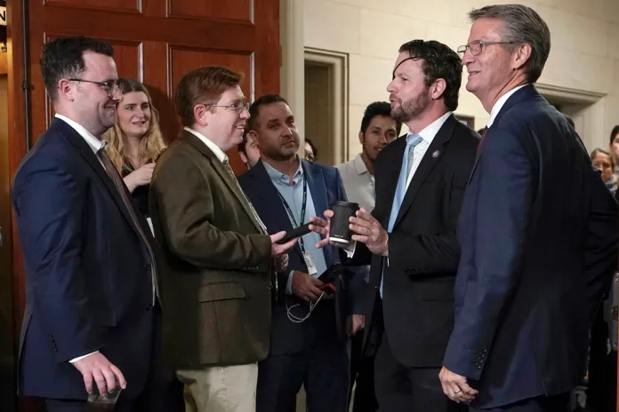 Rep. Dan Crenshaw, R-Texas, left, talk to reporters as the Republican caucus meets on Capitol Hill Tuesday, Oct. 24, 2023, in Washington. At right is Rep. Tim Burchett