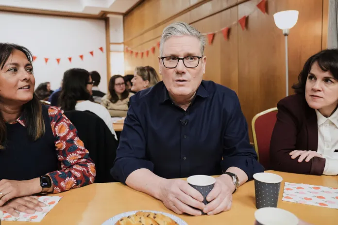 Keir Starmer sits at a table with Labour supporters
