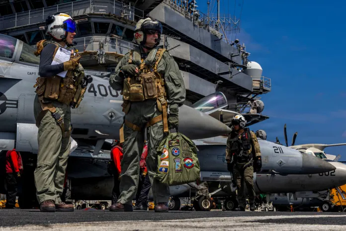 US military personnel stand on the deck of the USS Abraham Lincoln