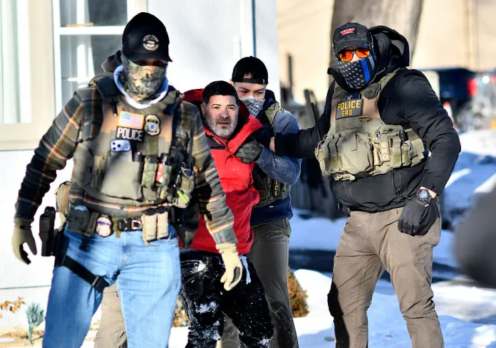 Federal immigration agents detain a man during an operation by US Immigration and Customs Enforcement (ICE) and Border Patrol in St. Paul, Minnesota, on January 27, 2026. On January 24, federal agents shot and killed Alex Pretti, a 37-year-old ICU nurse, while scuffling with him on an icy roadway in Minneapolis, less than three weeks after an immigration officer fired on Renee Good, also 37, killing her in her car. The fatal shootings has reignited accusations that federal agents enforcing US President Donald Trump's militarized immigration crackdown are inexperienced, under-trained and operating outside law enforcement norms. (Photo by Octavio JONES / AFP via Getty Images)