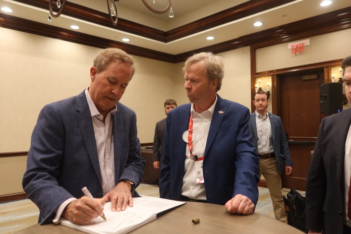 Attorney General Ken Paxton signs a book for a supporter at a meet and greet at CPAC on Saturday, March 28, 2026. (Samantha-Jo Roth, Washington Examiner)