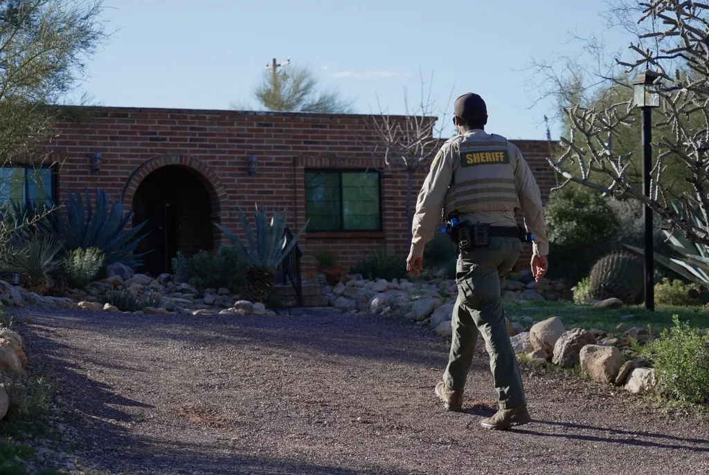 A member of the Pima County sheriffs office remains outside of Nancy Guthrie's home, Monday, Feb. 9, 2026 in Tucson, Ariz. (AP Photo/Ty ONeil)