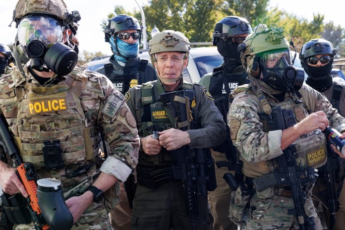 U.S. Customs and Border Protection Commander Gregory Bovino stands with federal immigration enforcement agents.