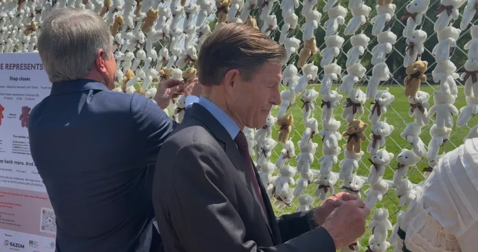 Rep. Michael McCaul (R-TX) and Sen. Richard Blumenthal (D-CT) attaching teddy bears to the installation. (Photo by Emily Robertson/Washington Examiner)