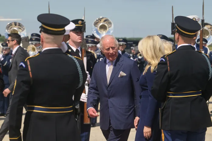 King Charles walks past US troops