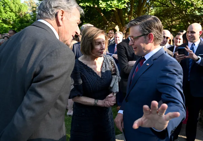 House Speaker Mike Johnson of La., talks with Rep. Nancy Pelosi, D-Calif., and her husband Paul before Britain's King Charles III and Queen Camilla arrive at a garden party at the British Embassy, Monday, April 27, 2026, in Washington. 