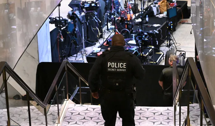 A Secret Service police officer walks through the lobby of the Washington Hilton after shots were heard during the White House Correspondents' Dinner in Washington, DC, on April 25, 2026. Shots were fired as US President Donald Trump attended a press dinner in Washington on April 25 night, witnesses and AFP reporters confirmed. Loud bangs were heard and guests at the black-tie White House Correspondents' Dinner scrambled to hide under tables. Tactical teams with guns drawn took position on the stage where Trump had been sitting before he was evacuated. (Photo by Alex WROBLEWSKI / AFP via Getty Images)