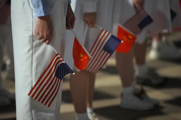 People hold American and Chinese flags for a welcome ceremony as President Donald Trump arrives on Air Force One, Wednesday, May 13, 2026, at Beijing Capital International Airport in Beijing. (AP Photo/Mark Schiefelbein)