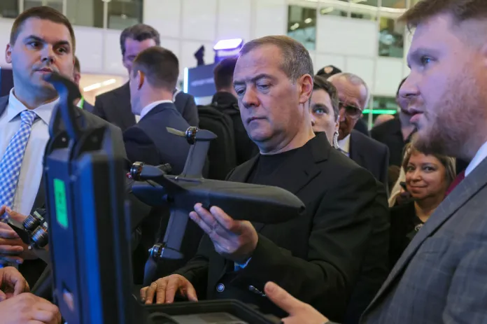 Dmitry Medvedev examines a drone.
